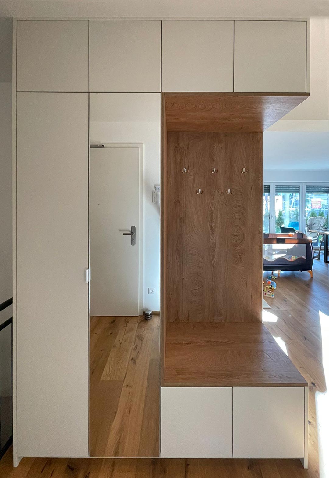 Garderobenschrank im Eingangsbereich mit Spiegel: Übergang zwischen Flur und Wohnzimmer